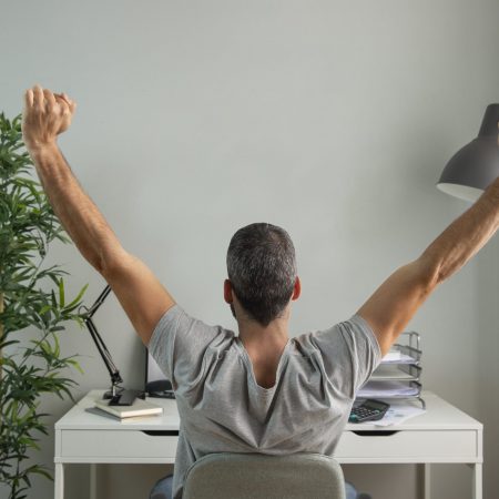 back-view-man-stretching-his-arms-while-working-from-home-scaled-1.jpg